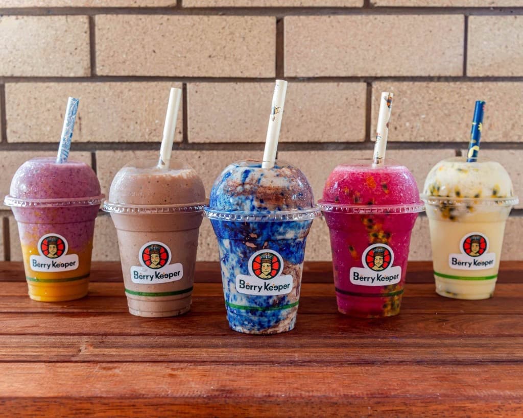 Five Berry Keeper smoothies lined up — berry, chocolate, blue spirulina, pitaya and passion fruit